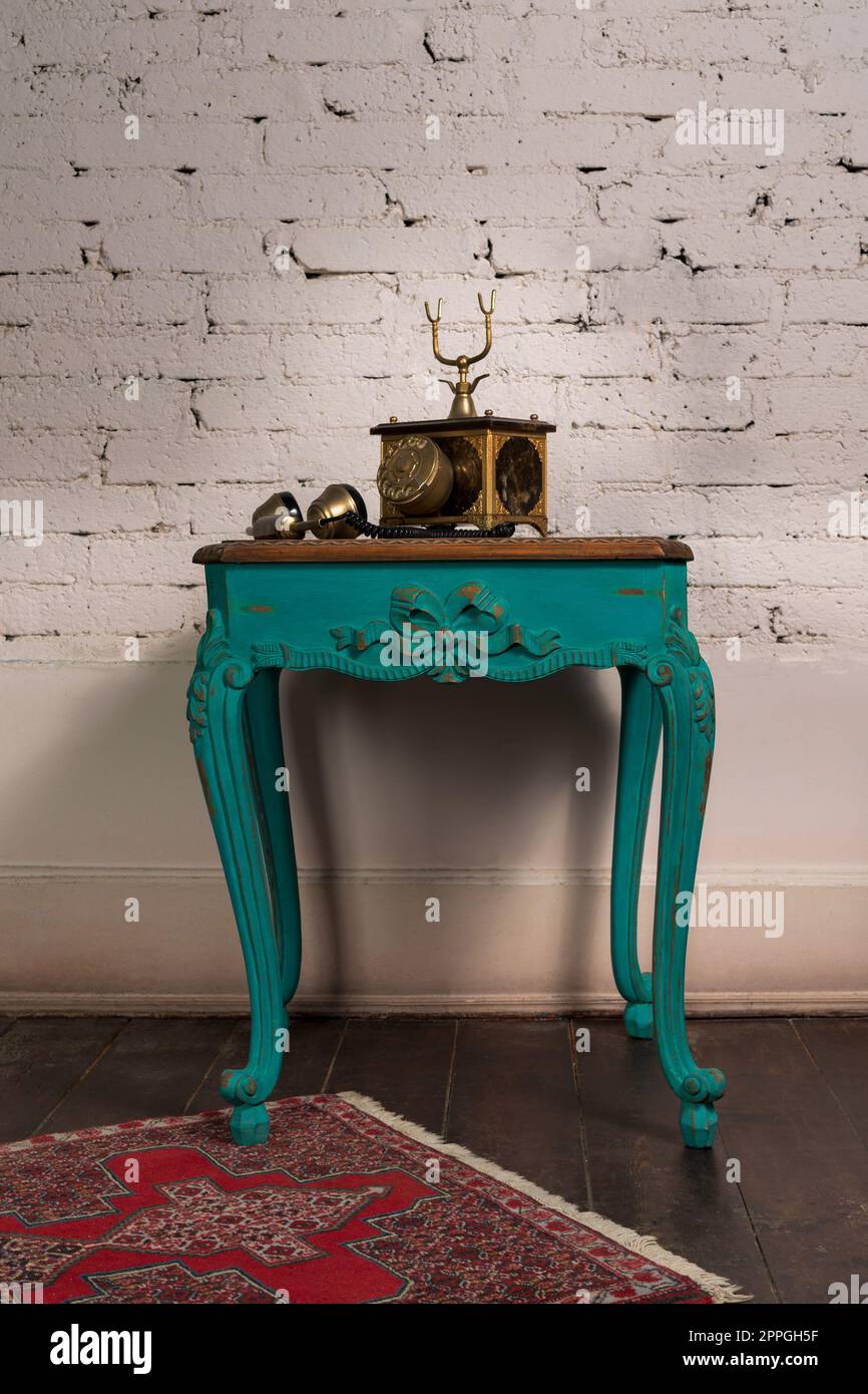 Green vintage wooden table and old golden telephone set Stock Photo