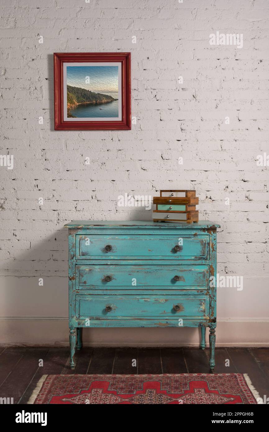 White brick wall with shabby chic vintage turquoise cabinet and hanged painting Stock Photo