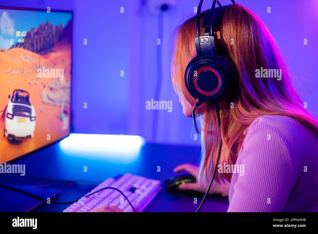 Young player woman wearing gaming headphones intend to do playing live stream games online Stock Photo