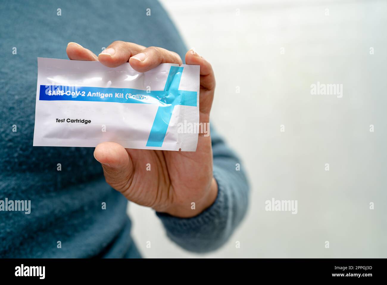 Asian doctor in PPE suit show positive test result with Saliva Antigen Test Kit for check