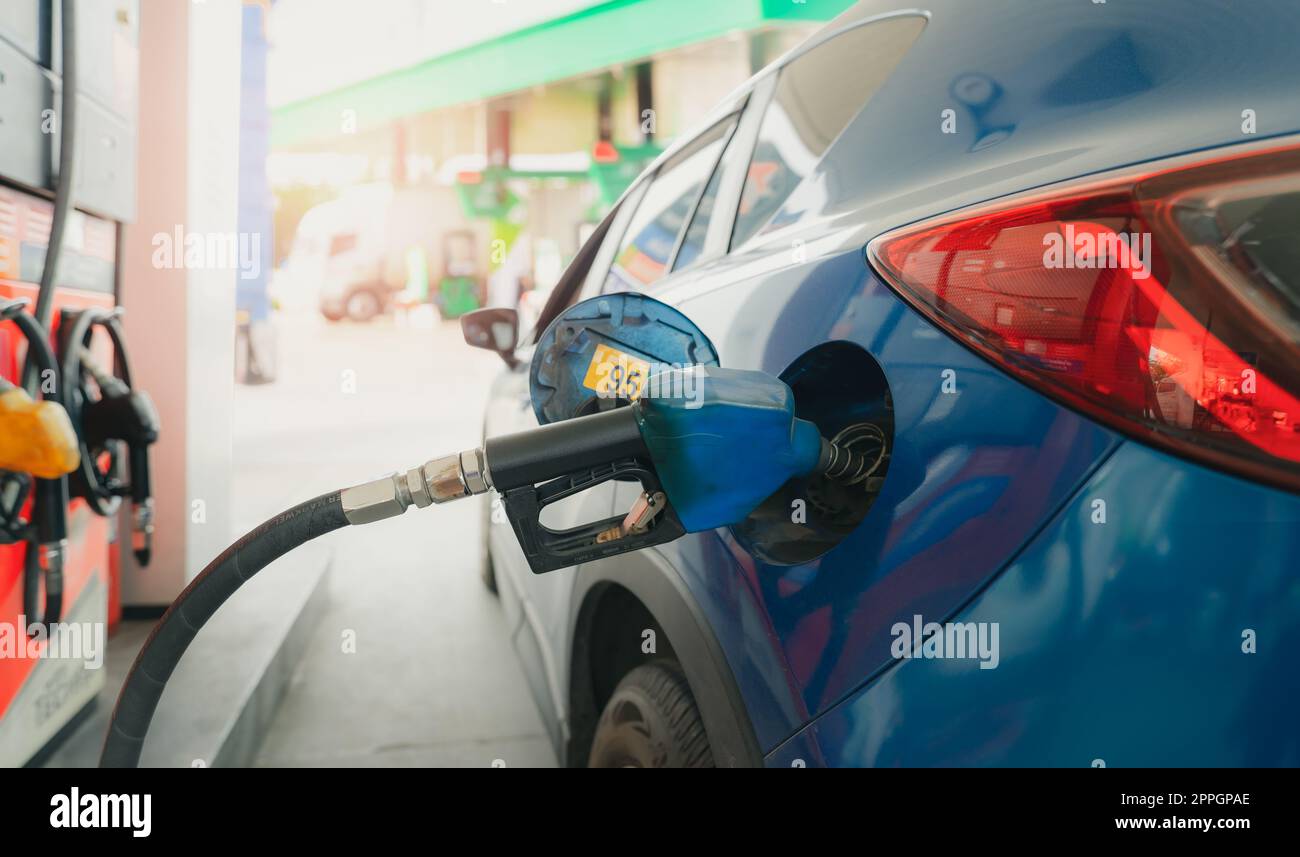 Car fueling at gas station. Refuel fill up with petrol gasoline. Petrol pump filling fuel nozzle in fuel tank of car at gas station. Petrol industry and service. Petrol price and oil crisis concept. Stock Photo