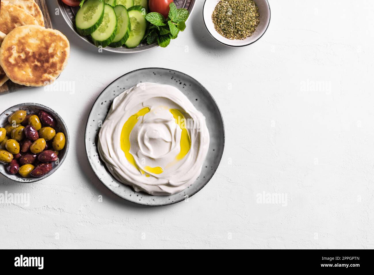 Labneh yogurt cream cheese with olive oil, zaatar, olives, vegetables