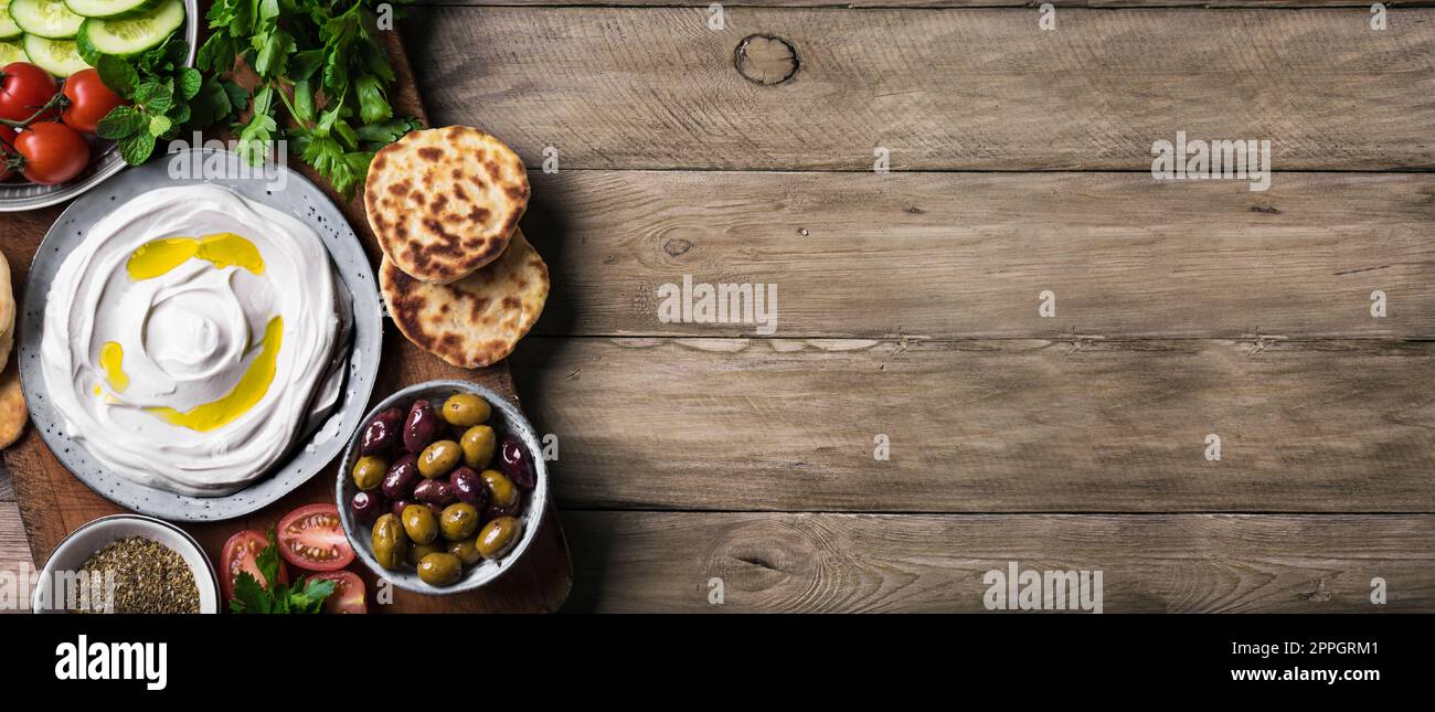 Labneh yogurt cream cheese with olive oil, zaatar, olives, vegetables