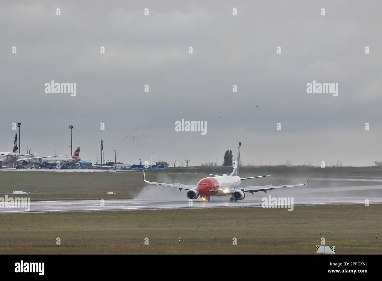 Plane landing in rain Stock Photo