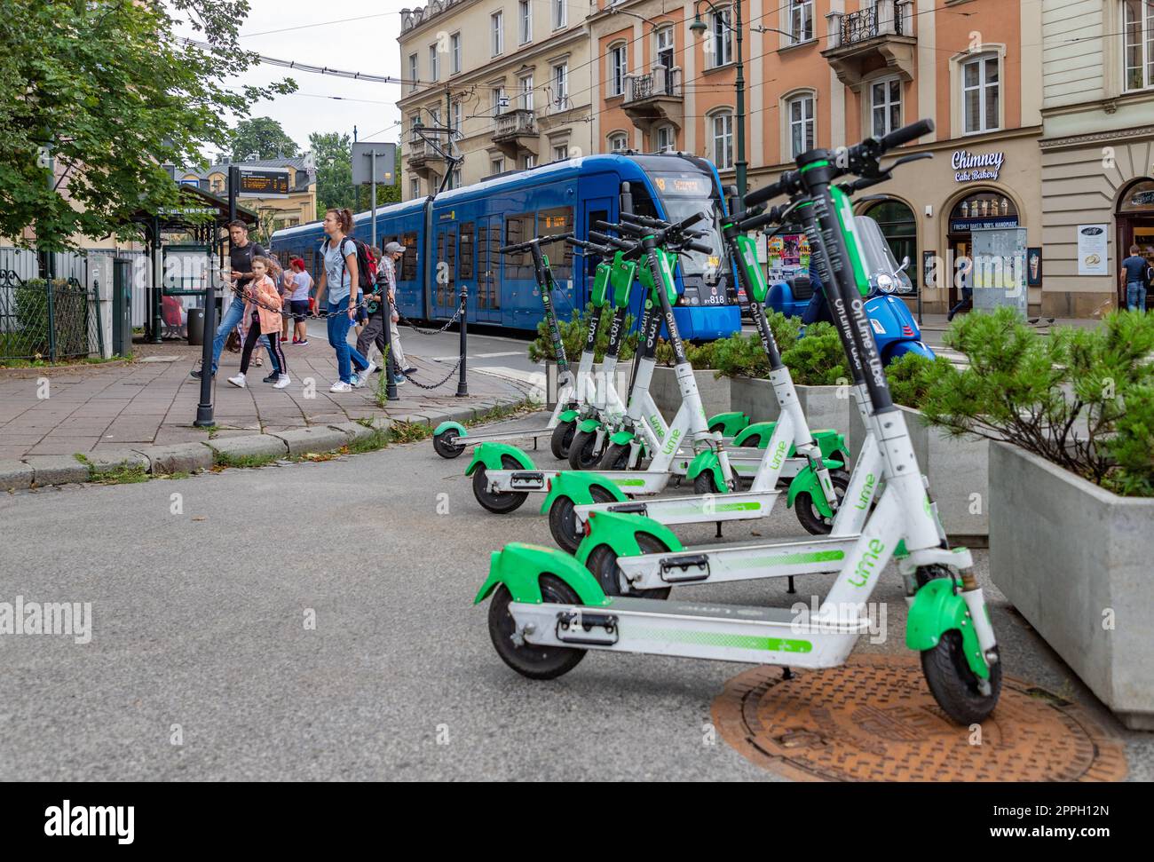 A picture of a group of Lime electric scooters parked on the sidewalk