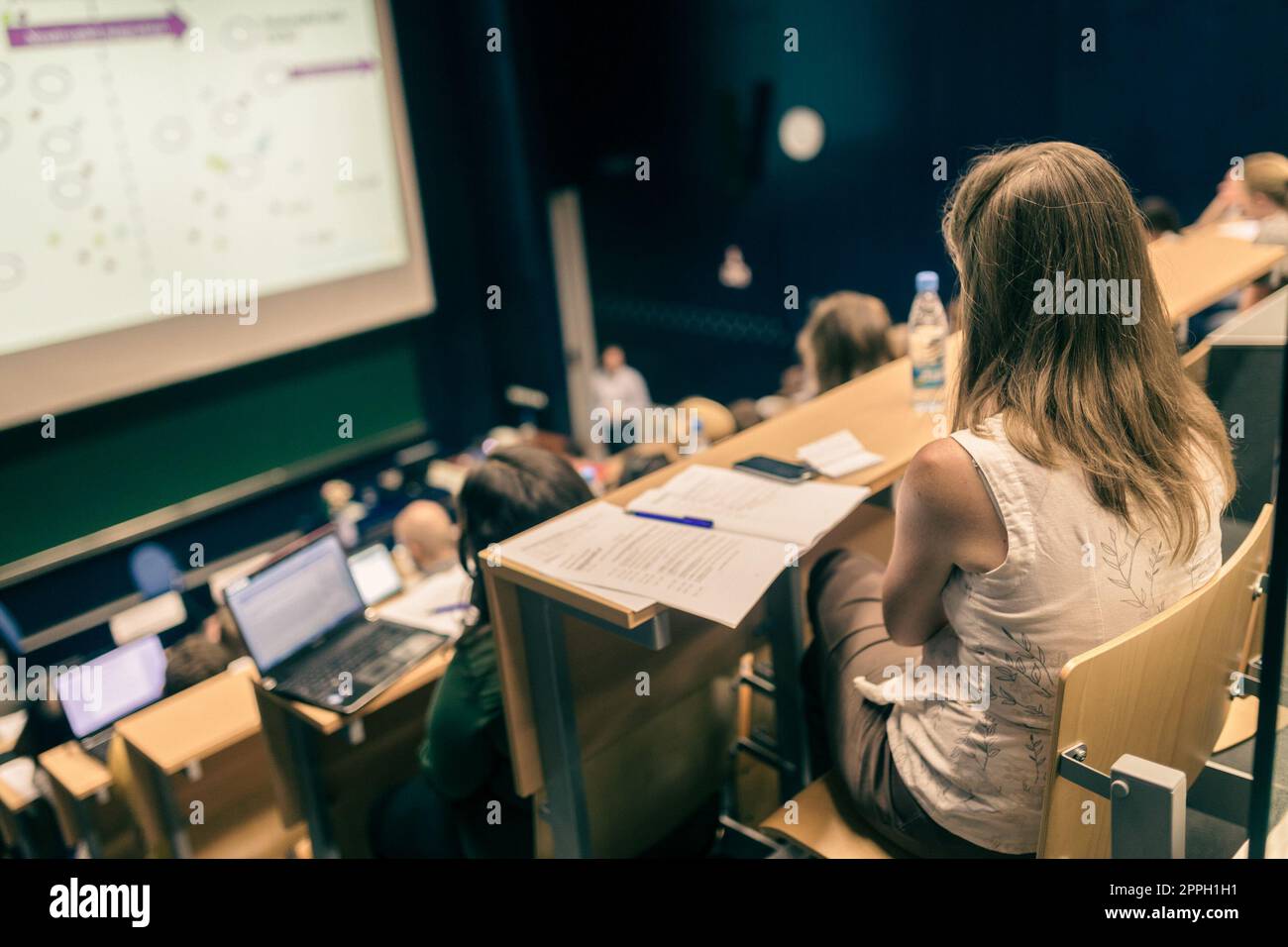 Conference and Presentation. Audience at the conference hall. Business and Entrepreneurship. Faculty lecture and workshop. Audience in the lecture hall. Academic education. Student making notes Stock Photo