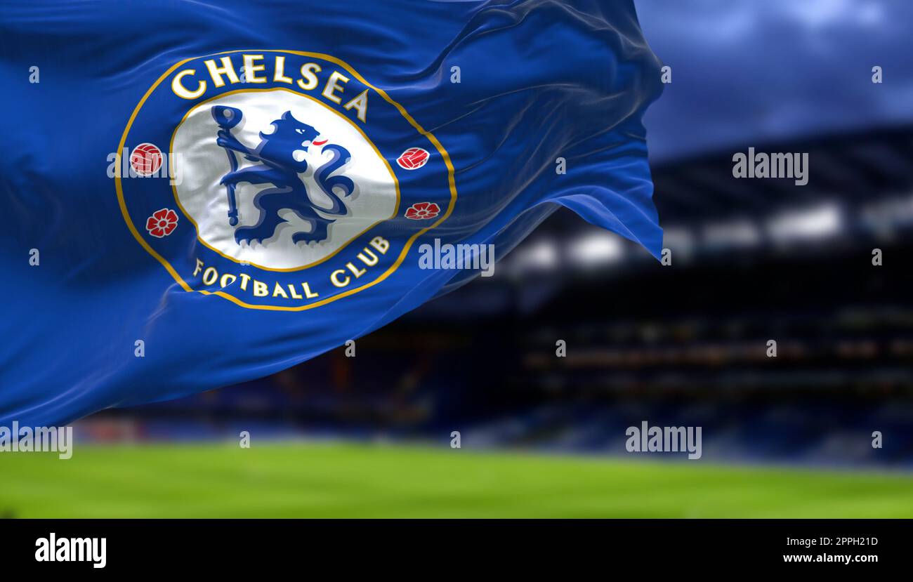 The flag of Chelsea Football Club waving inside the Stamford Bridge stadium at night Stock Photo