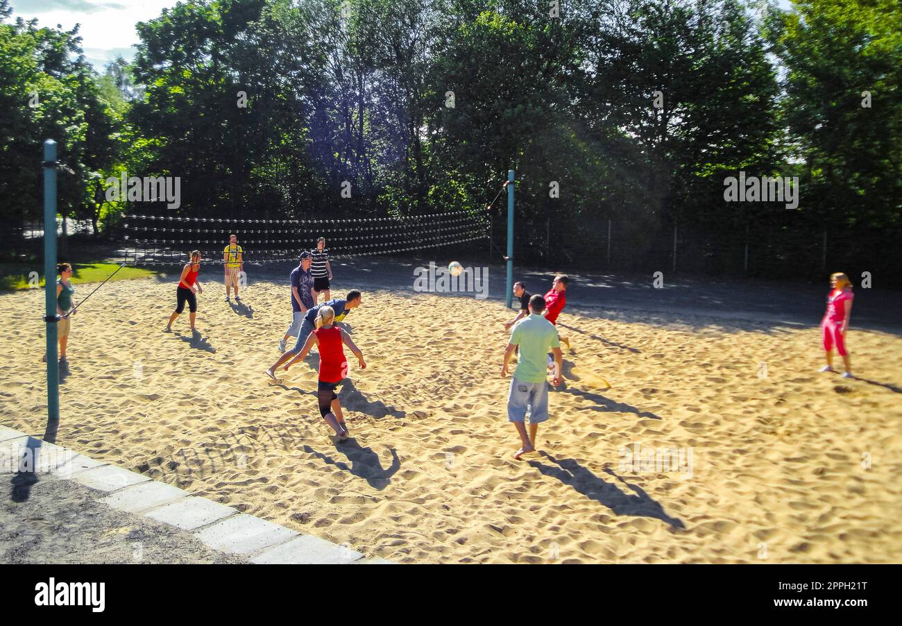 Teenagers play volleyball outside with net and volleyball court Germany. Stock Photo