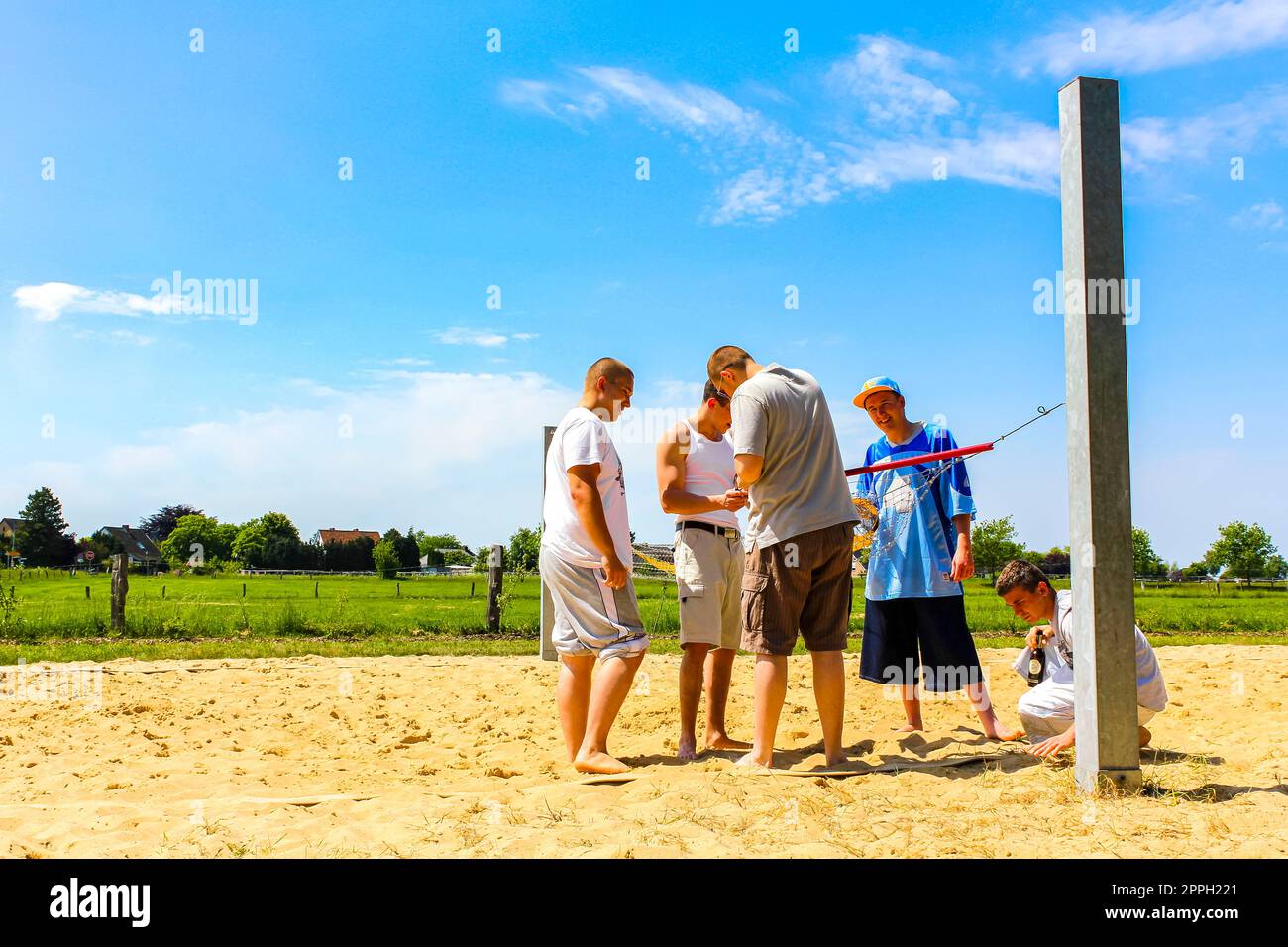 Teenagers play volleyball outside with net and volleyball court Germany