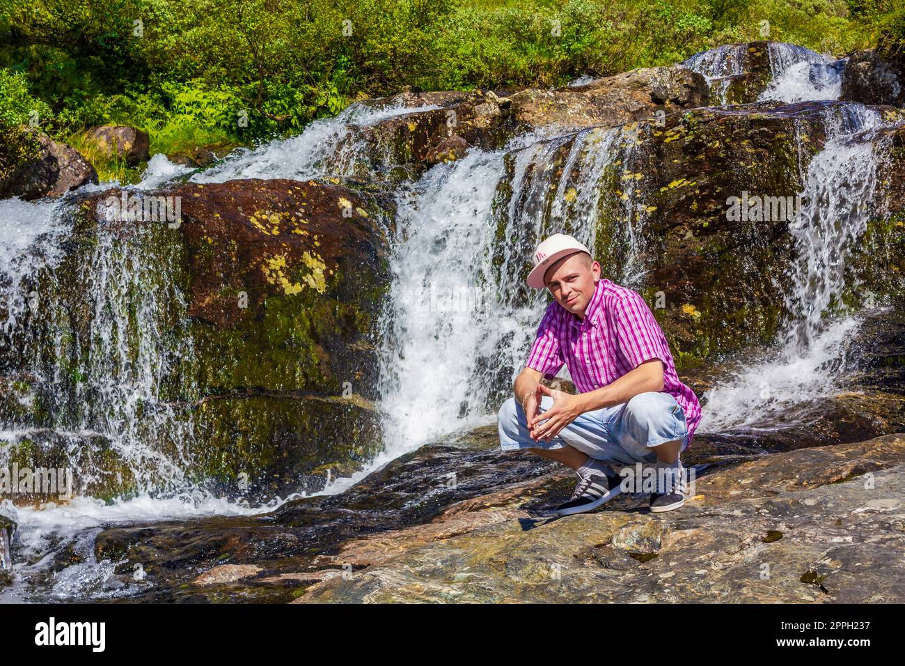 Man tourist in front of beautiful waterfall river Vang Norway. Stock Photo