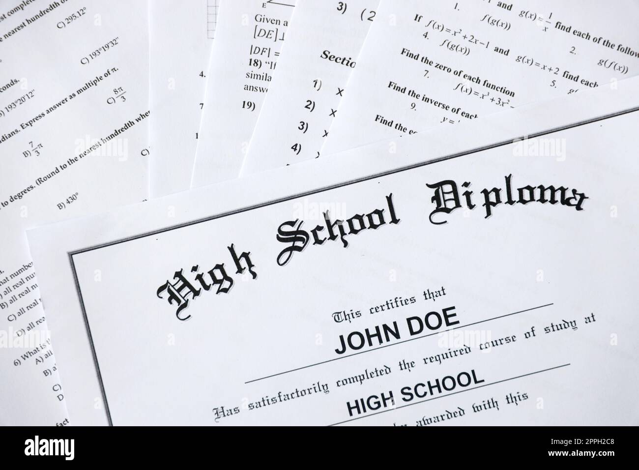 High School Diploma copy lies on many pages of alghebra and geometry tests and tasks. Graduation document Stock Photo