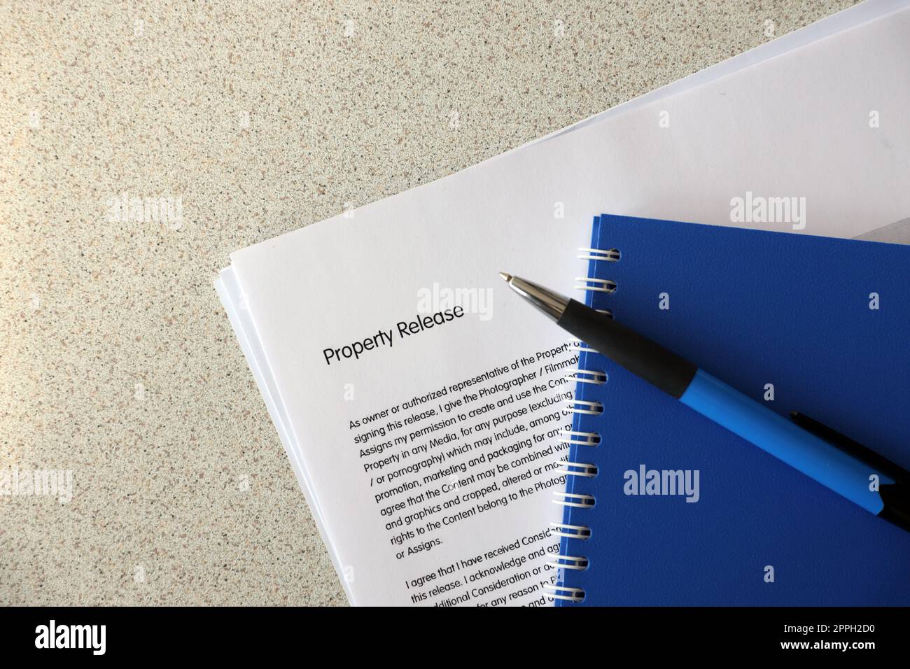 Property release blank form with blue notepad and blue pen lies on photographers table. Property release signing photo Stock Photo