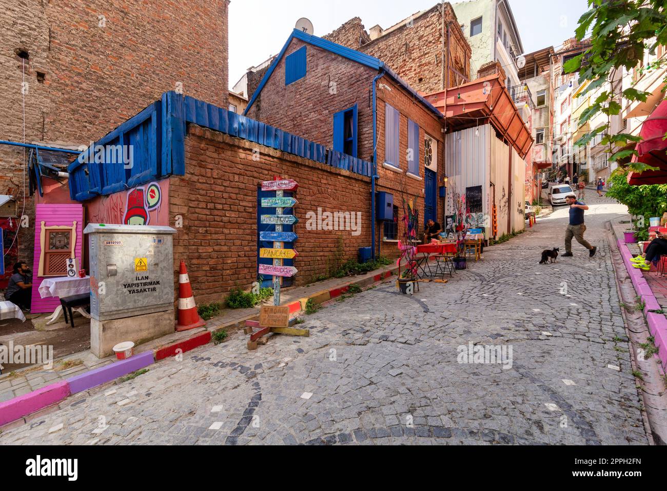 Alley with cobblestone floor, and red stone bricks old buildings in Balat district, Istanbul, Turkey Stock Photo