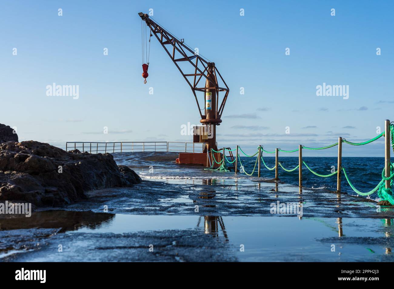 Berth with a crane on the north coast of the Atlantic Ocean, the village of El Pris. Tenerife. Canary Islands. Spain. Stock Photo