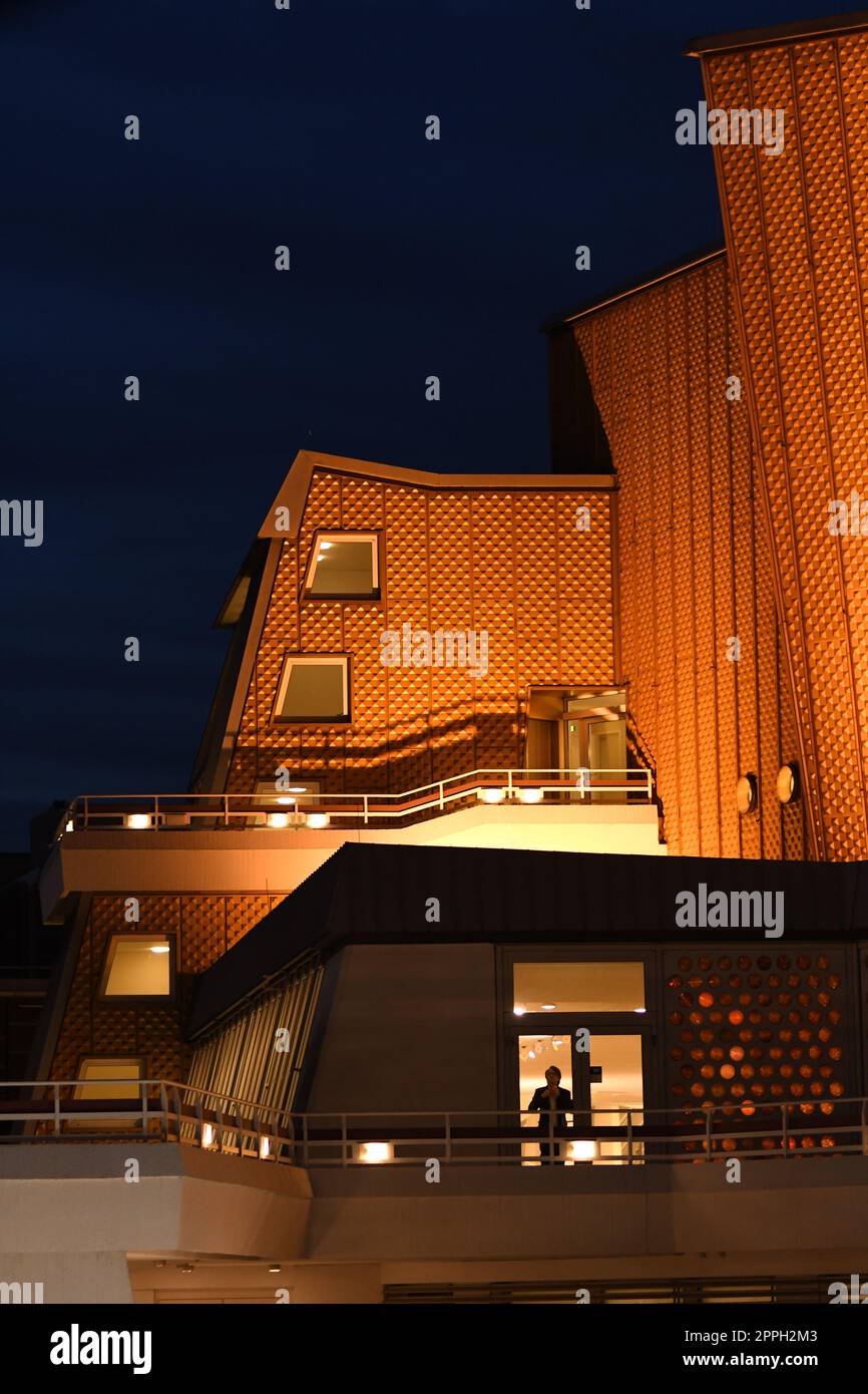 Vertical shot of the golden building of the Berlin Philharmonic Hall at night in Berlin, Germany Stock Photo