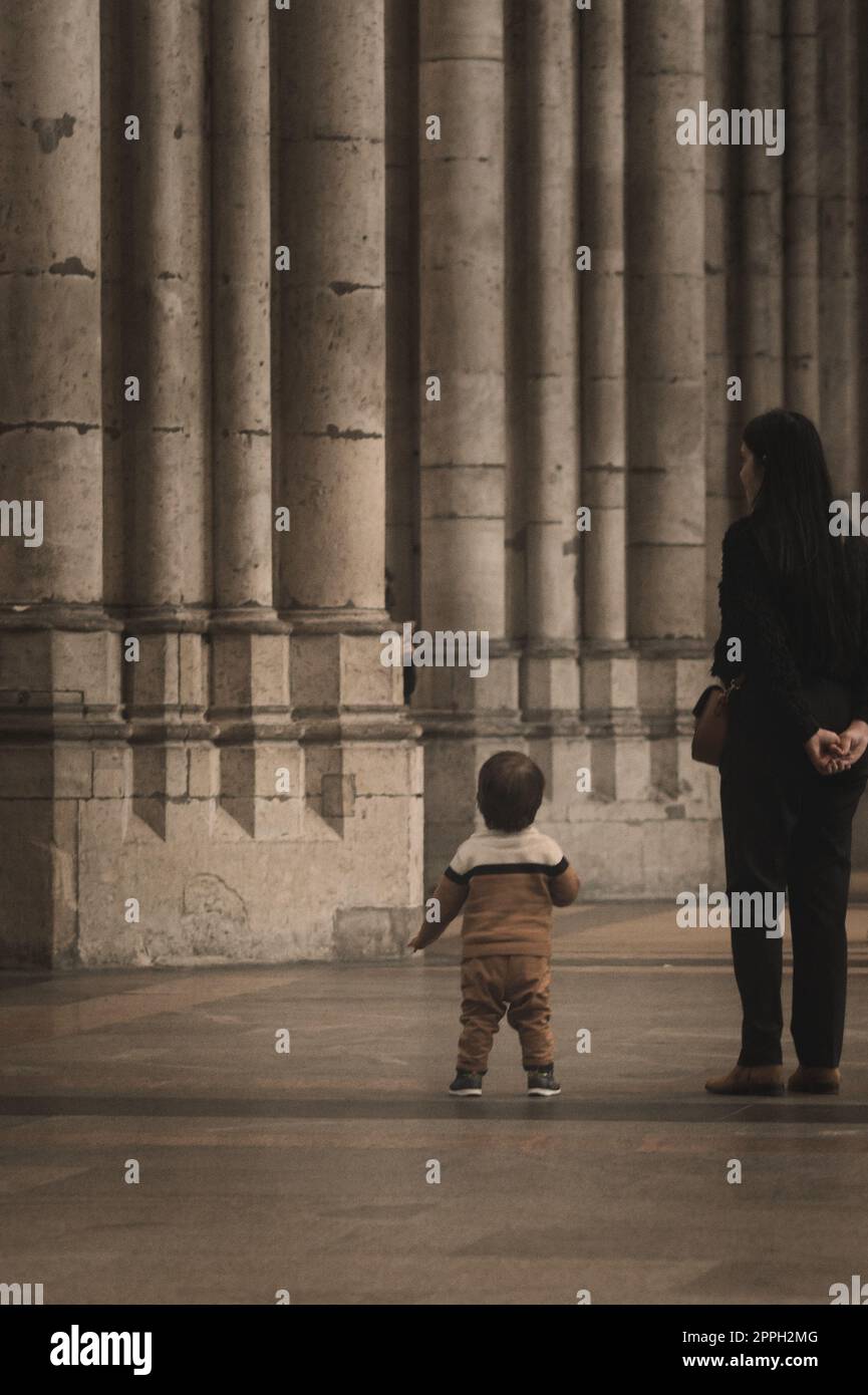 Little boy looks in wonder at the huge stone columns in Cologne Cathedral in Cologne, Germany Stock Photo