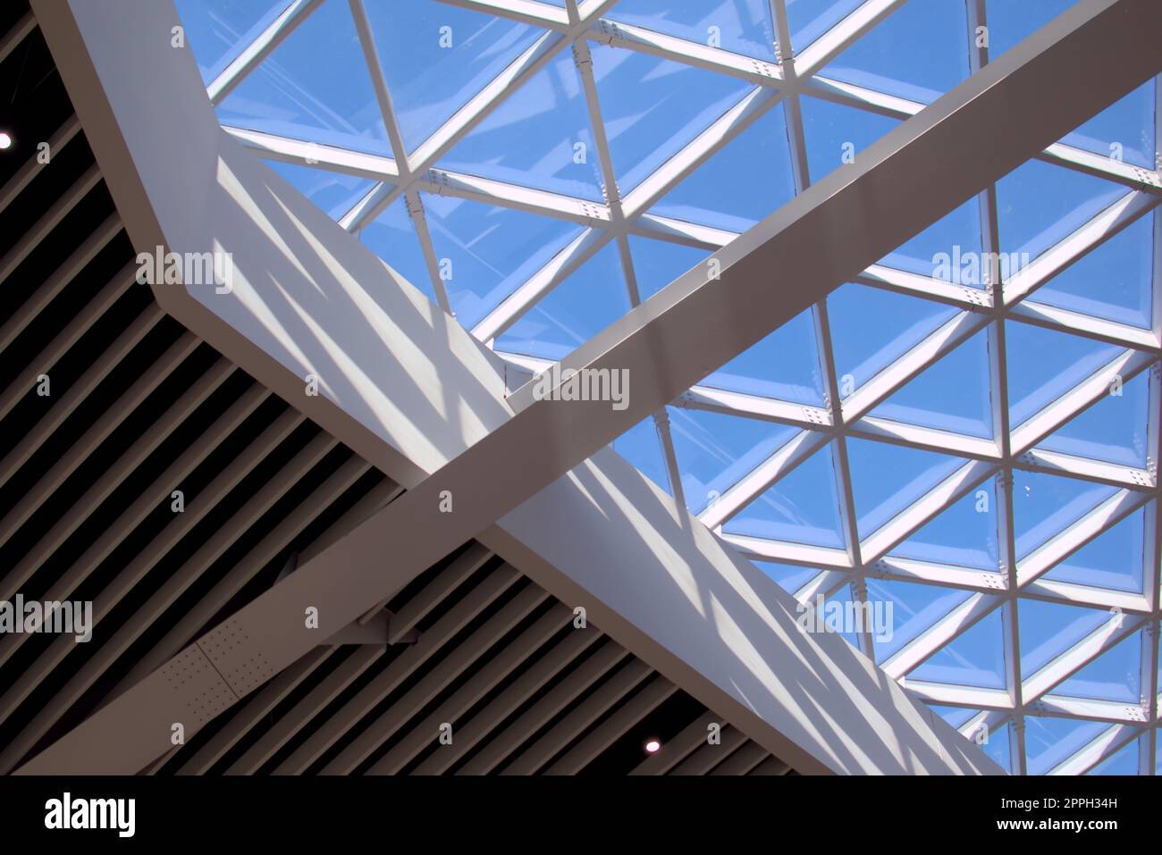 Large, modern design glass skylight at an airport. The beams form triangular patterns. Stock Photo