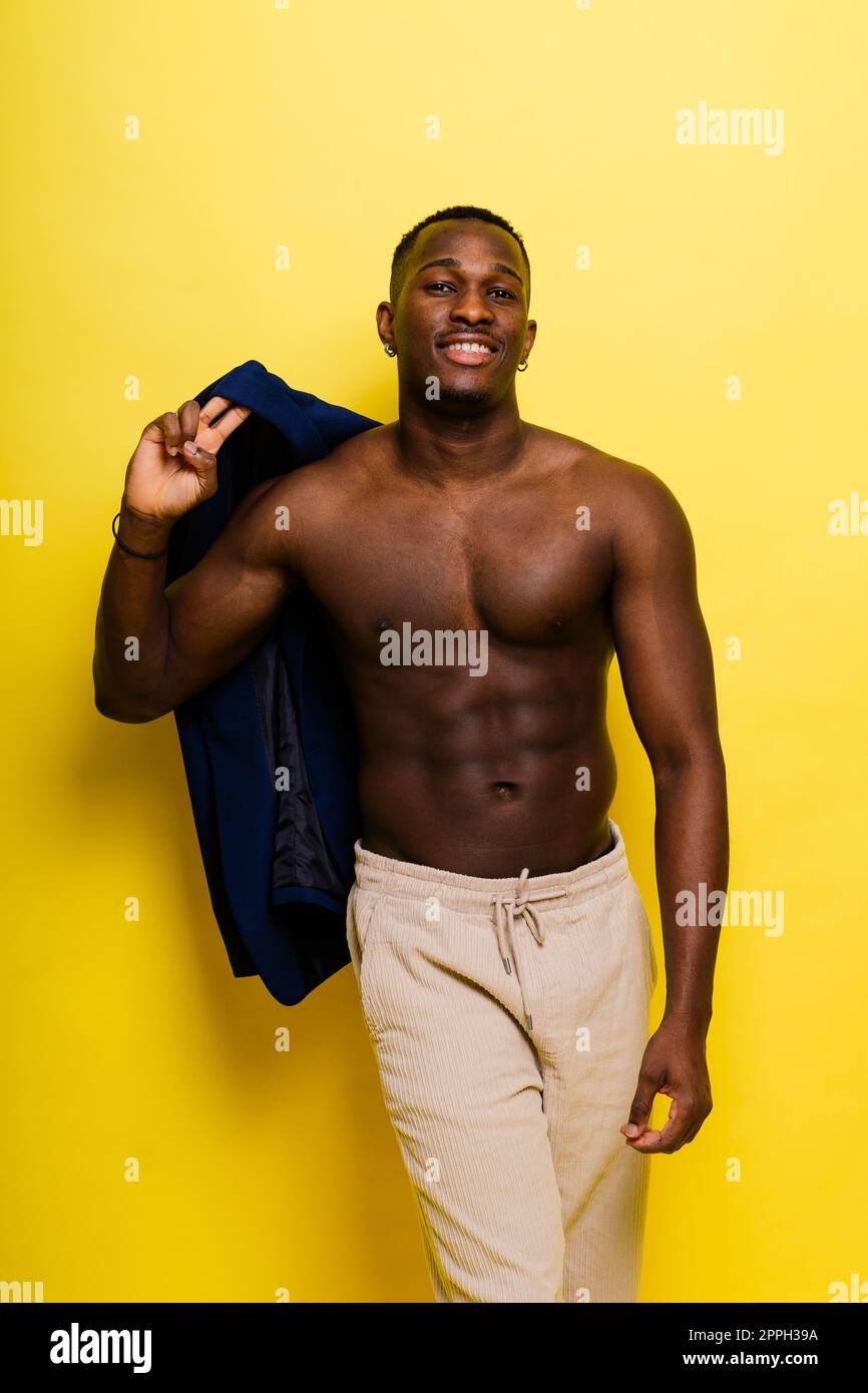 Guy in blue suit on a yellow background. Handsome athletic man in