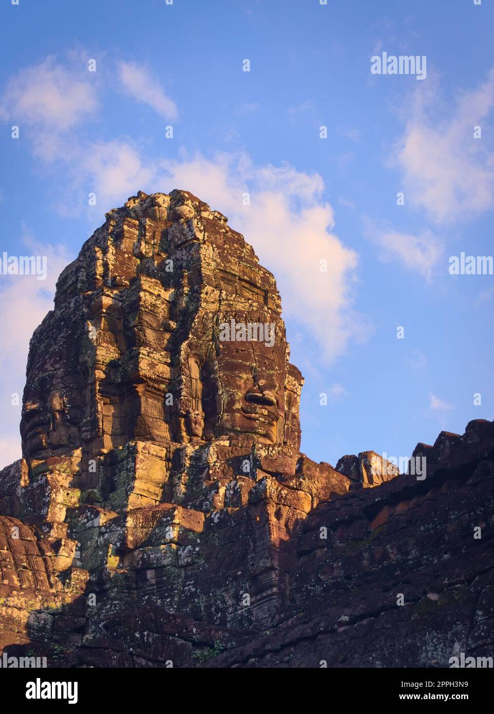 Massive stone face tower at Bayon temple, located in Angkor, Cambodia, the ancient capital city of the Khmer empire. View from the western inner courtyard. Stock Photo