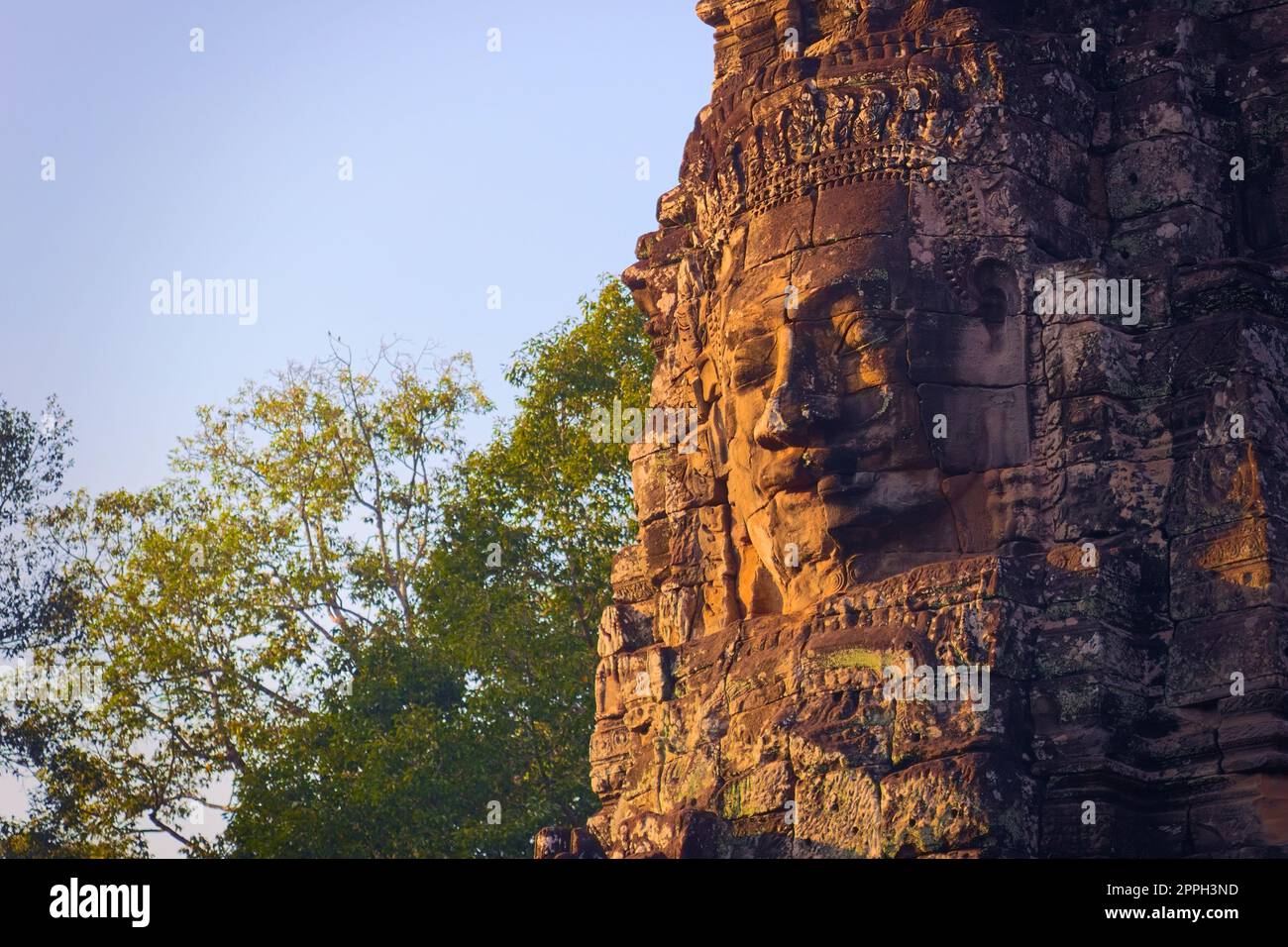 Cambodian stone face at Bayon temple, located in Angkor, Cambodia, ancient capital of the Khmer empire. Stock Photo