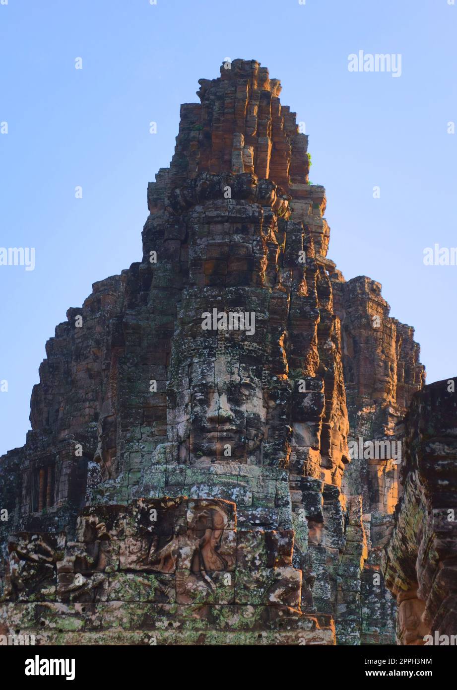 Stone face tower on the Bayon temple, located in Angkor, Cambodia, the ancient capital of the Khmer empire. Stock Photo