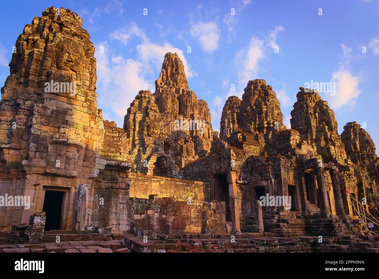 Bayon temple, located in Angkor, Cambodia, the ancient capital city of the Khmer empire. View of the massive stone face towers from the western inner courtyard. Stock Photo