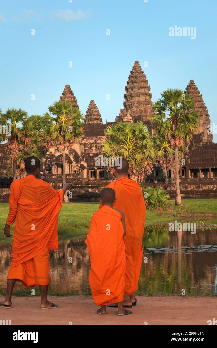 Three young monks at Angkor Wat, in traditional saffron colored robes