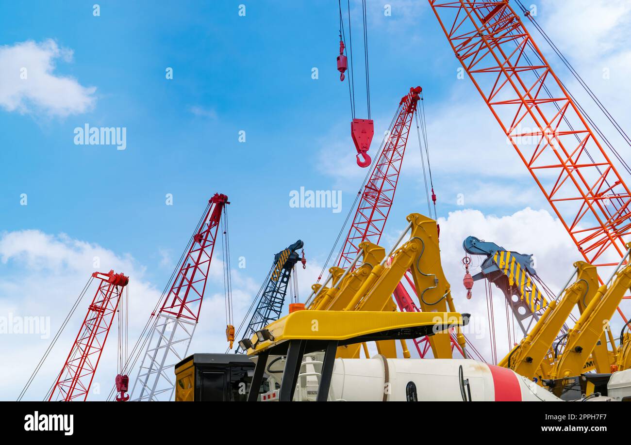 Crawler crane against blue sky. Real estate industry. Red crawler crane use reel lift up equipment in construction site. Crane for rent at parking lot. Crane dealership for construction business. Stock Photo