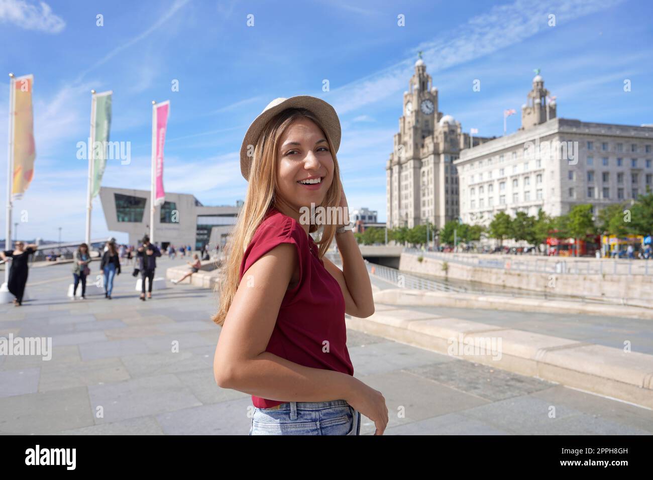 Smiling girl walking in Pier Head riverside in the city centre of