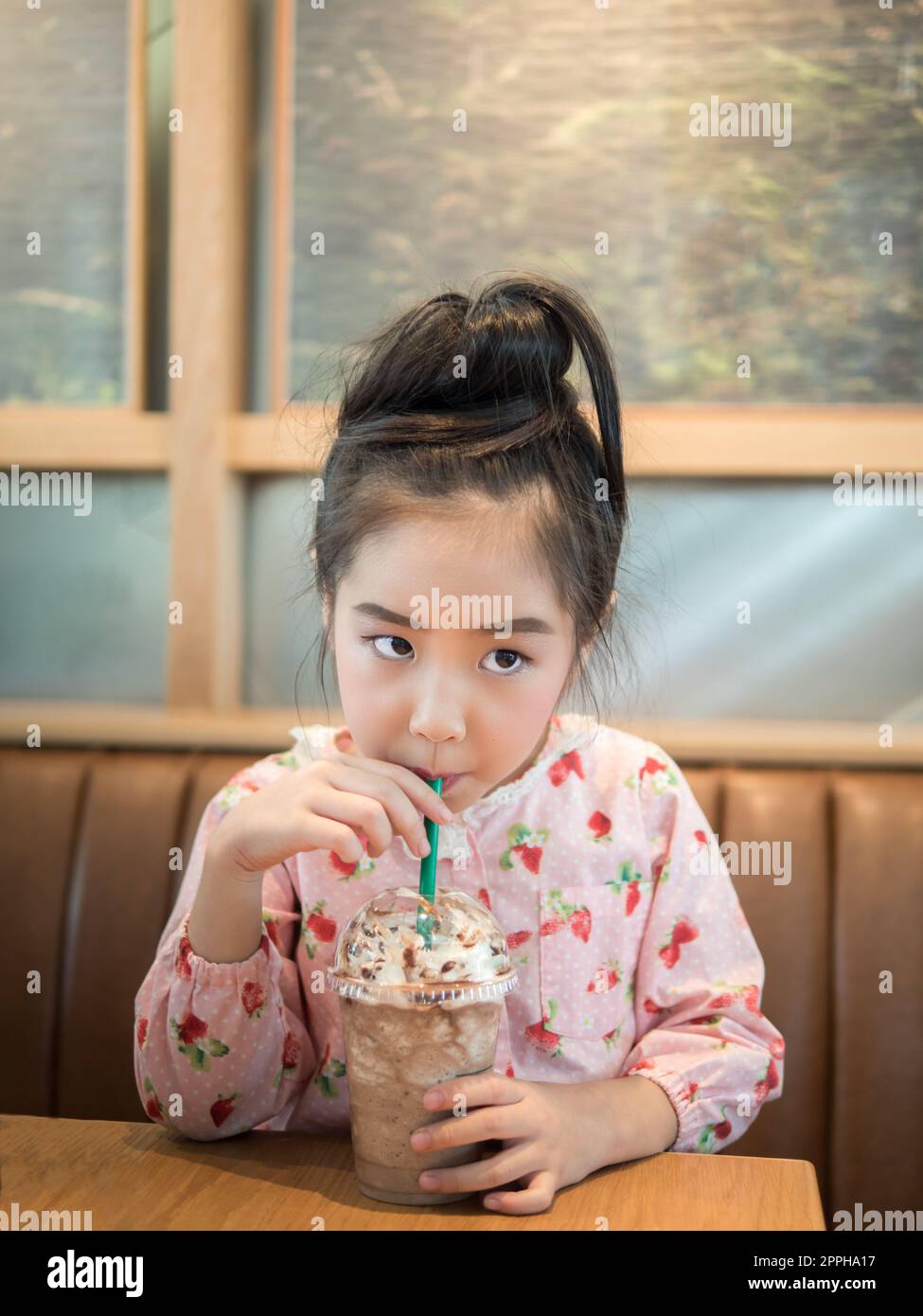 Beautiful asian girl drinking iced chocolate in the cafe, use a straw