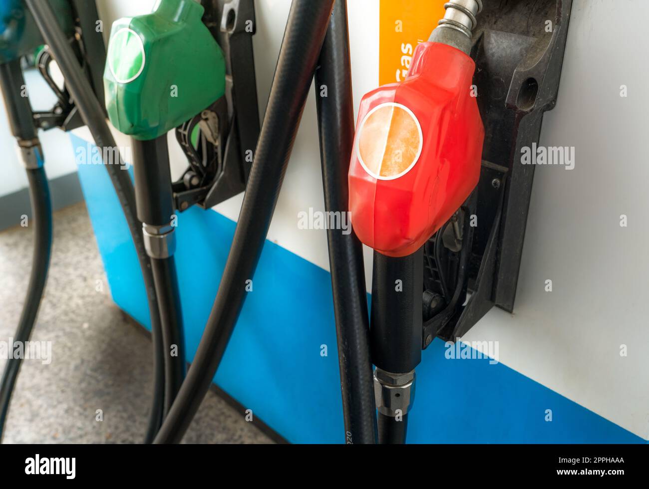 Petrol pump filling fuel nozzle in gas station. Fuel dispenser. Refuel fill up with petrol gasoline. Gas pump handle. Red petrol fuel nozzle. Petroleum oil industry. Oil crisis. Petrol price crisis. Stock Photo