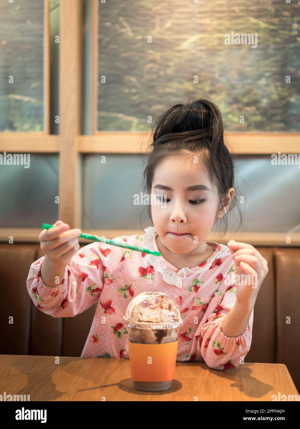 Beautiful asian girl drinking iced chocolate in the cafe, use a straw