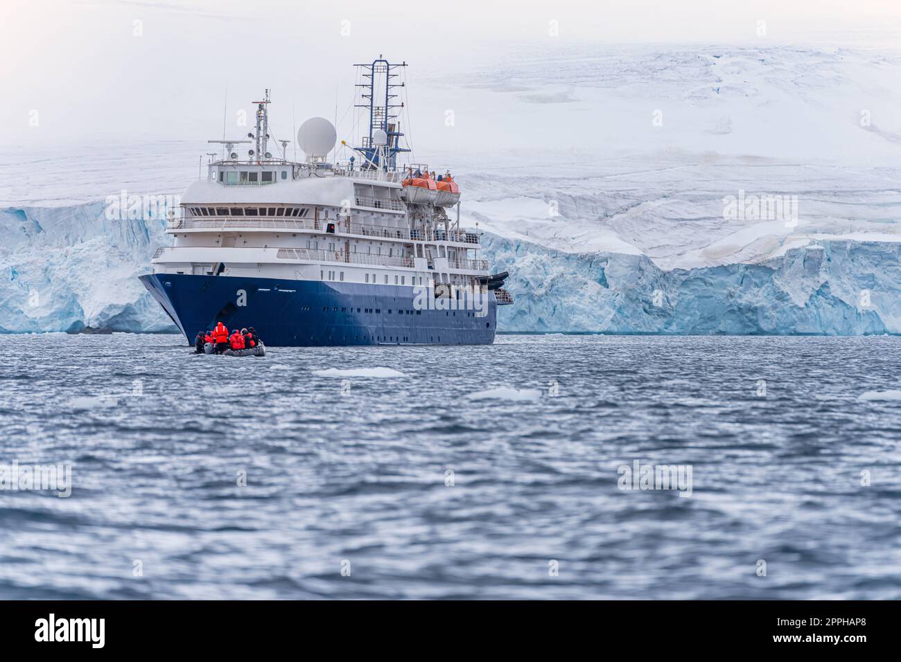 expedition ship in front of Antarctic iceberg landscape in Cierva Cove on the west side of the Antarctic Peninsula Stock Photo