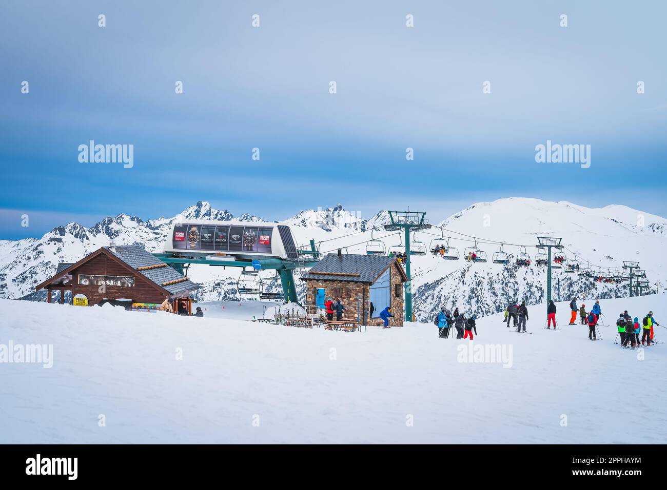 Group of people, skiers and snowboarders taking of from ski lift, Pyrenees, Andorra Stock Photo