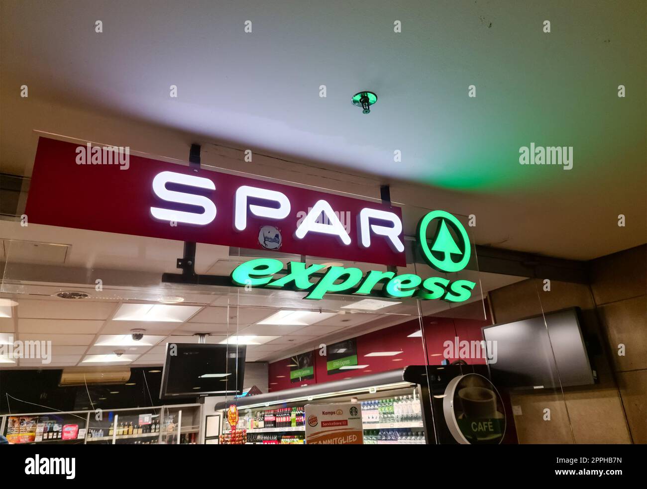 Hamburg, Germany - 16. October 2022: A big illuminated logo of the supermarket company name Spar at the entrance of a shop. Stock Photo