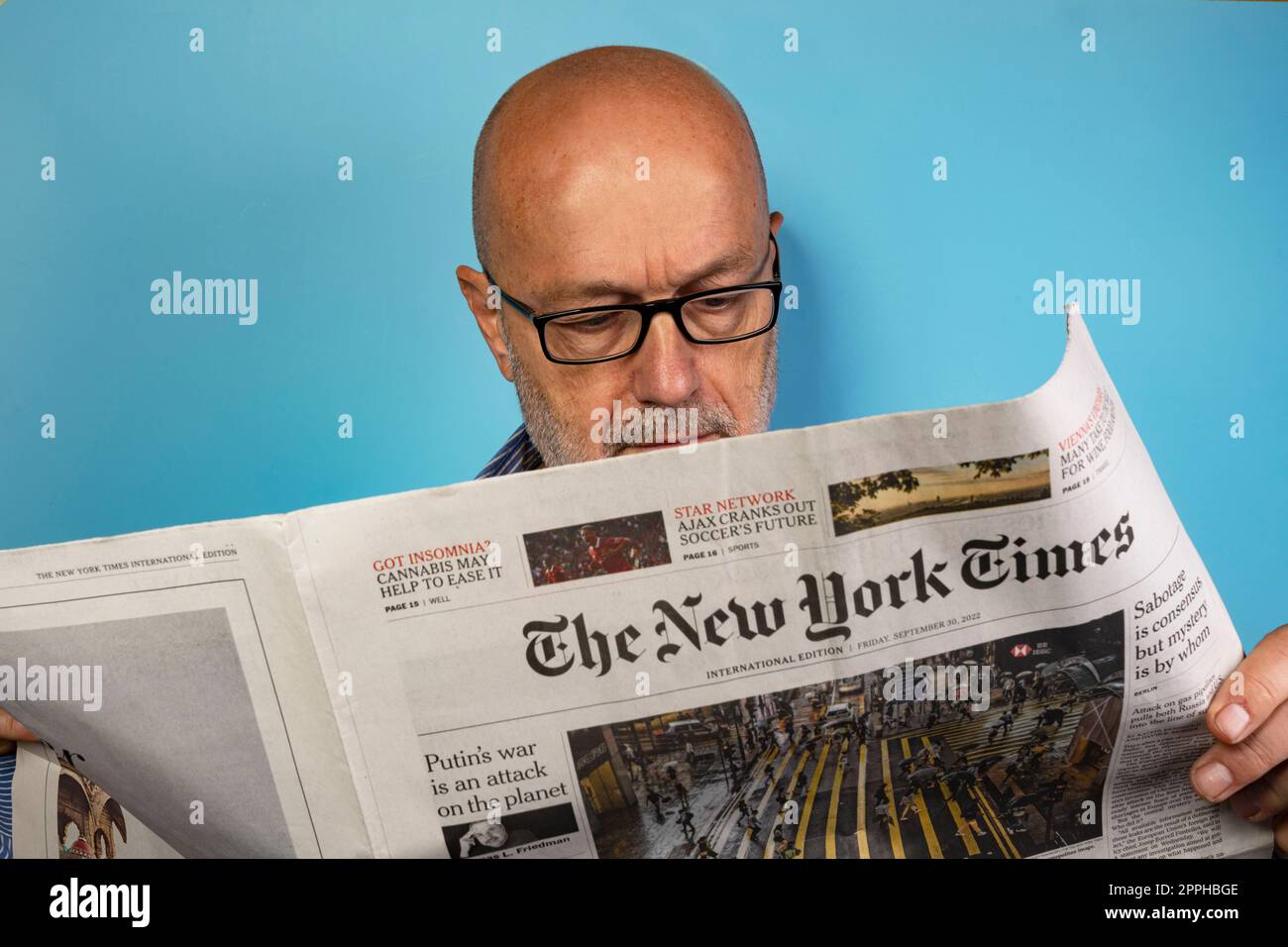 Reading the New York Times newspaper Stock Photo - Alamy