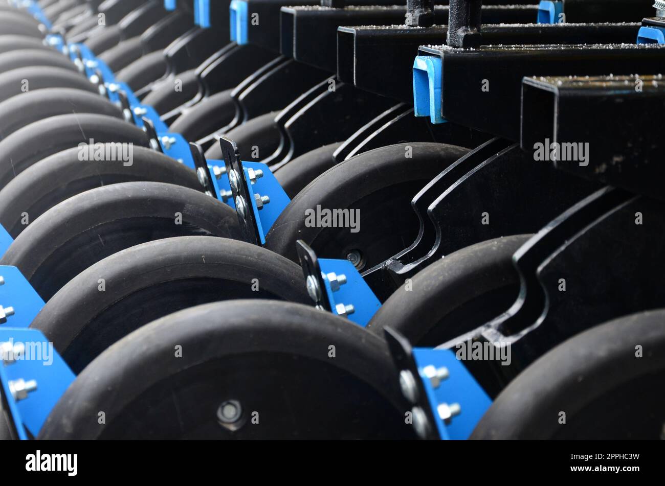 Row of wheels of the new industrial agricultural seeder close up Stock