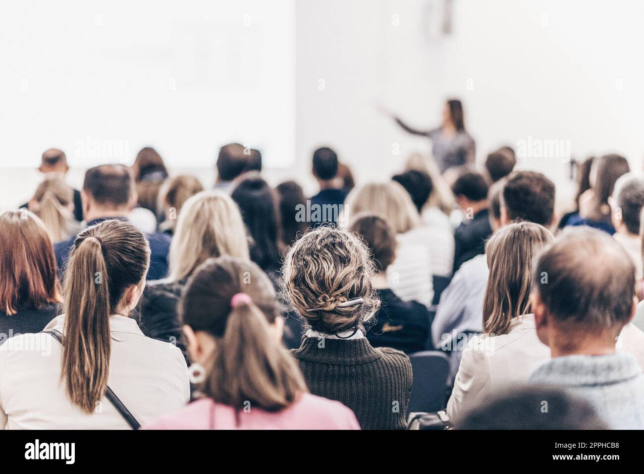 Female speaker giving a talk at business meeting. Audience in conference hall. Business and entrepreneurship symposium. Stock Photo