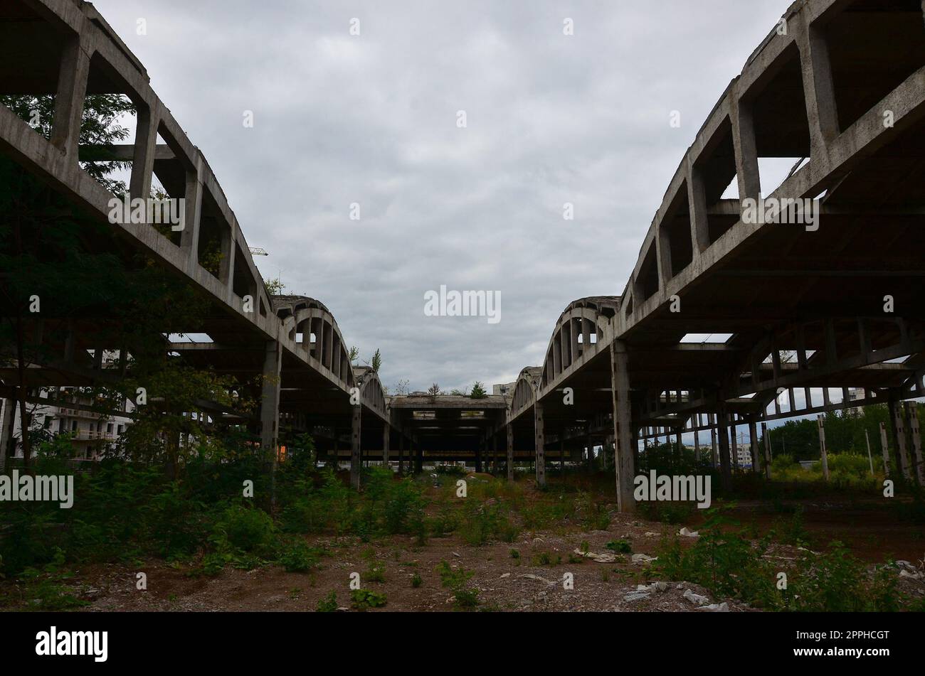 Landscape image of an abandoned industrial hangar with a damaged roof. Photo on wide-angle lens Stock Photo