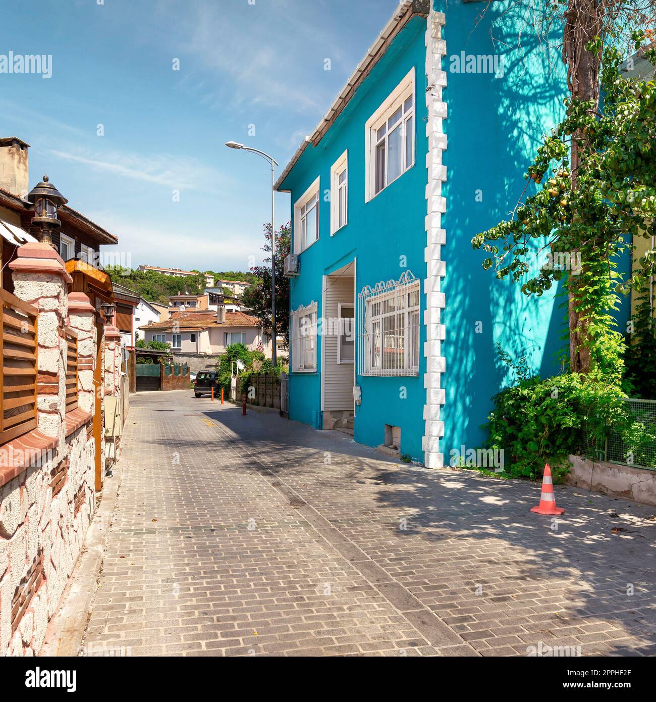 Cobblestone alley, with beautiful old traditional blue house, suited in Anadolu Kavagi district, Istanbul, Turkey Stock Photo