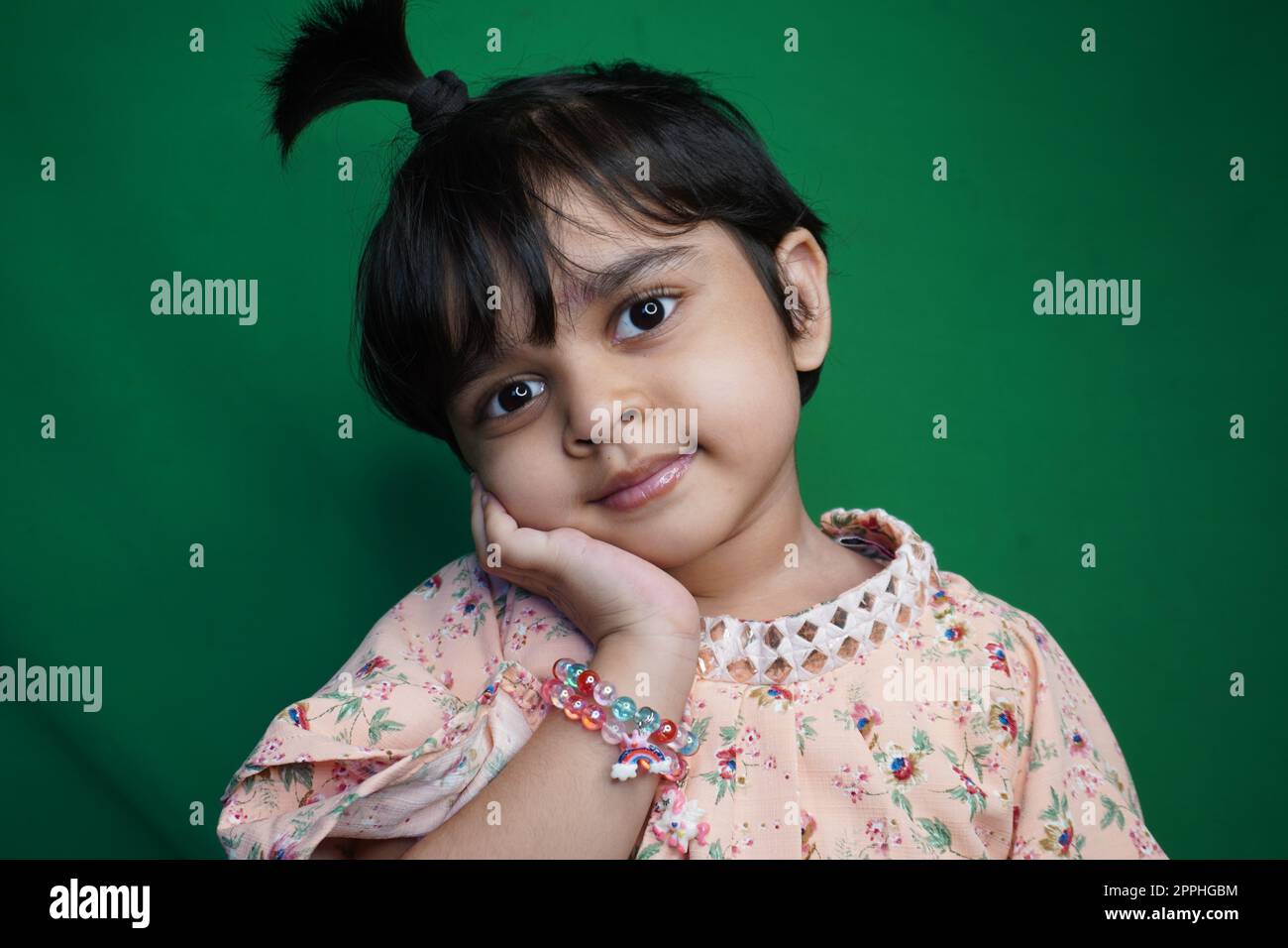 Portrait of Innocent little cute girl giving her best studio shoots on green screen background photo stock image in HD Stock Photo