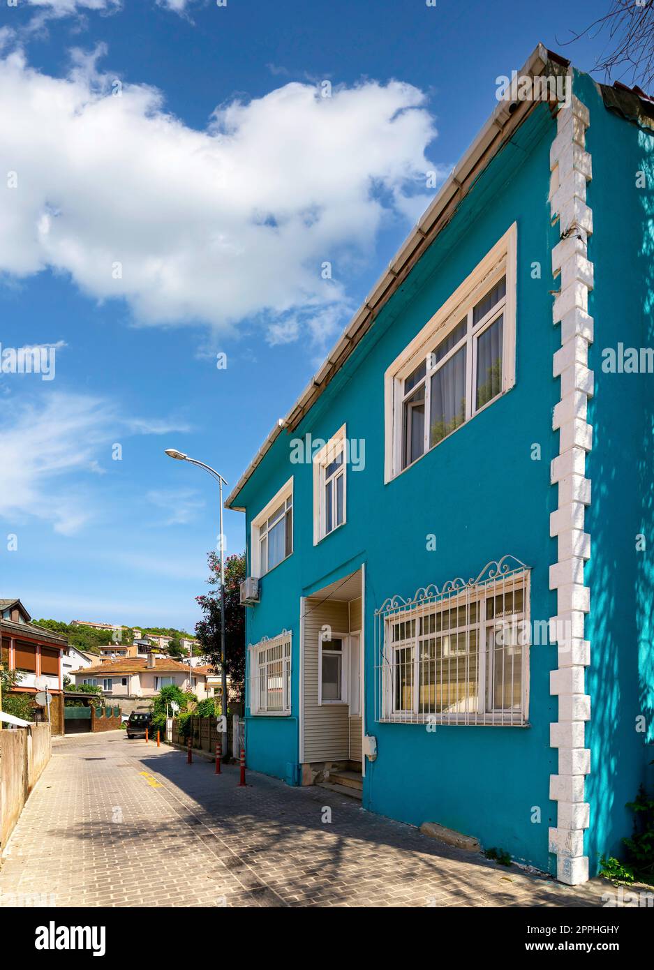 Cobblestone alley, with beautiful old traditional blue house, suited in Anadolu Kavagi district, Istanbul, Turkey Stock Photo