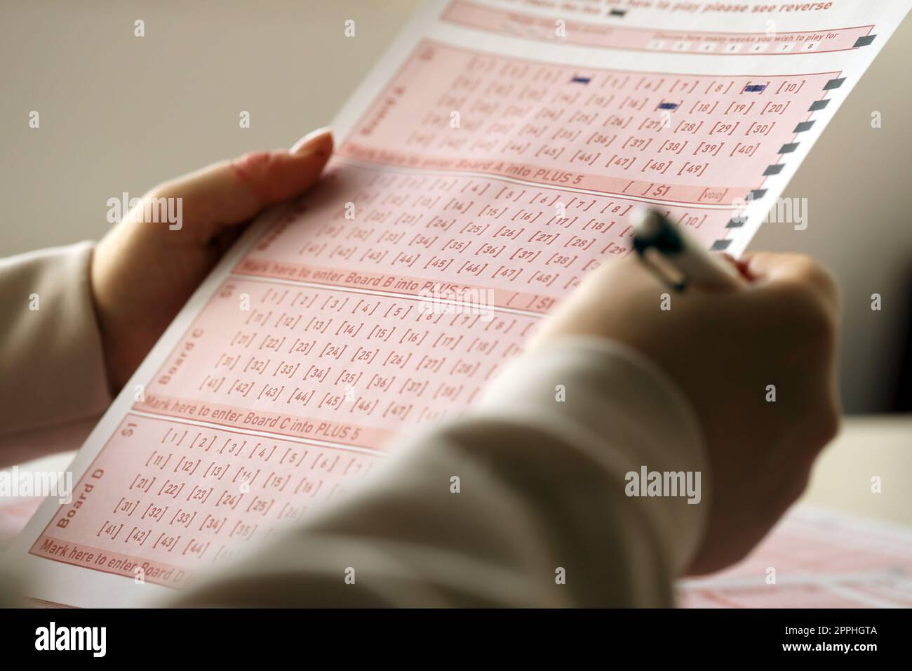 Filling out a lottery ticket. A young woman plays the lottery and dreams of winning the jackpot Stock Photo