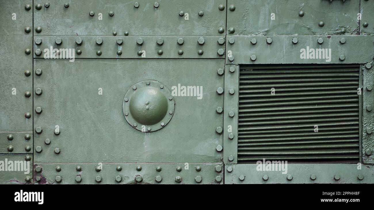 The texture of the wall of the tank, made of metal and reinforced with a multitude of bolts and rivets. Images of the covering of a combat vehicle from the Second World War Stock Photo