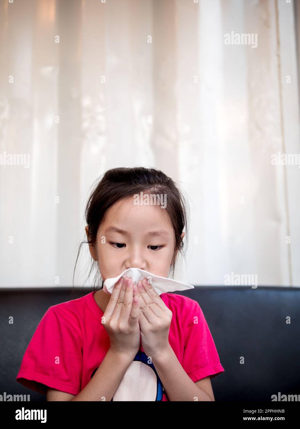 Young Asian girl wiping her mouth after snack Stock Photo Alamy