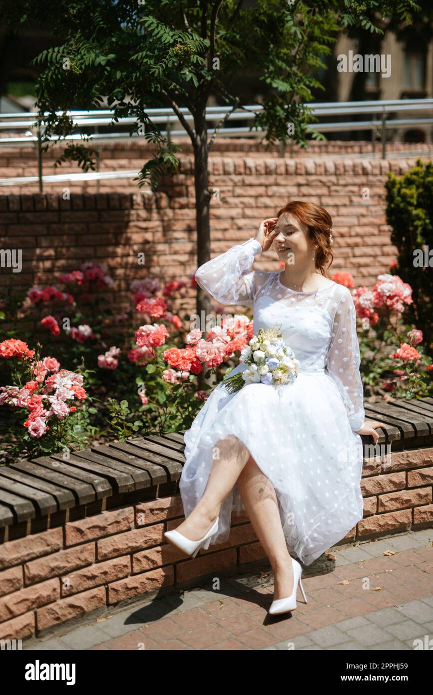 portrait of a young bride girl in a light dress in an urban environment Stock Photo