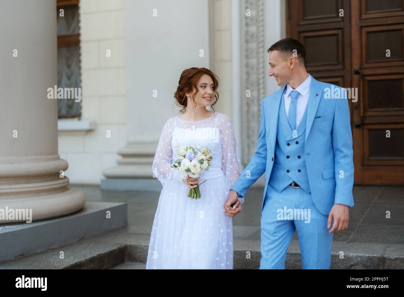 bride in a light wedding dress to the groom in a blue suit Stock Photo ...