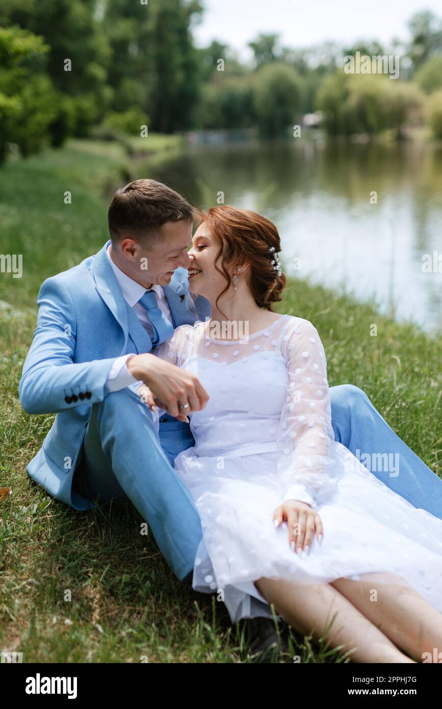 bride in a light wedding dress to the groom in a blue suit Stock Photo