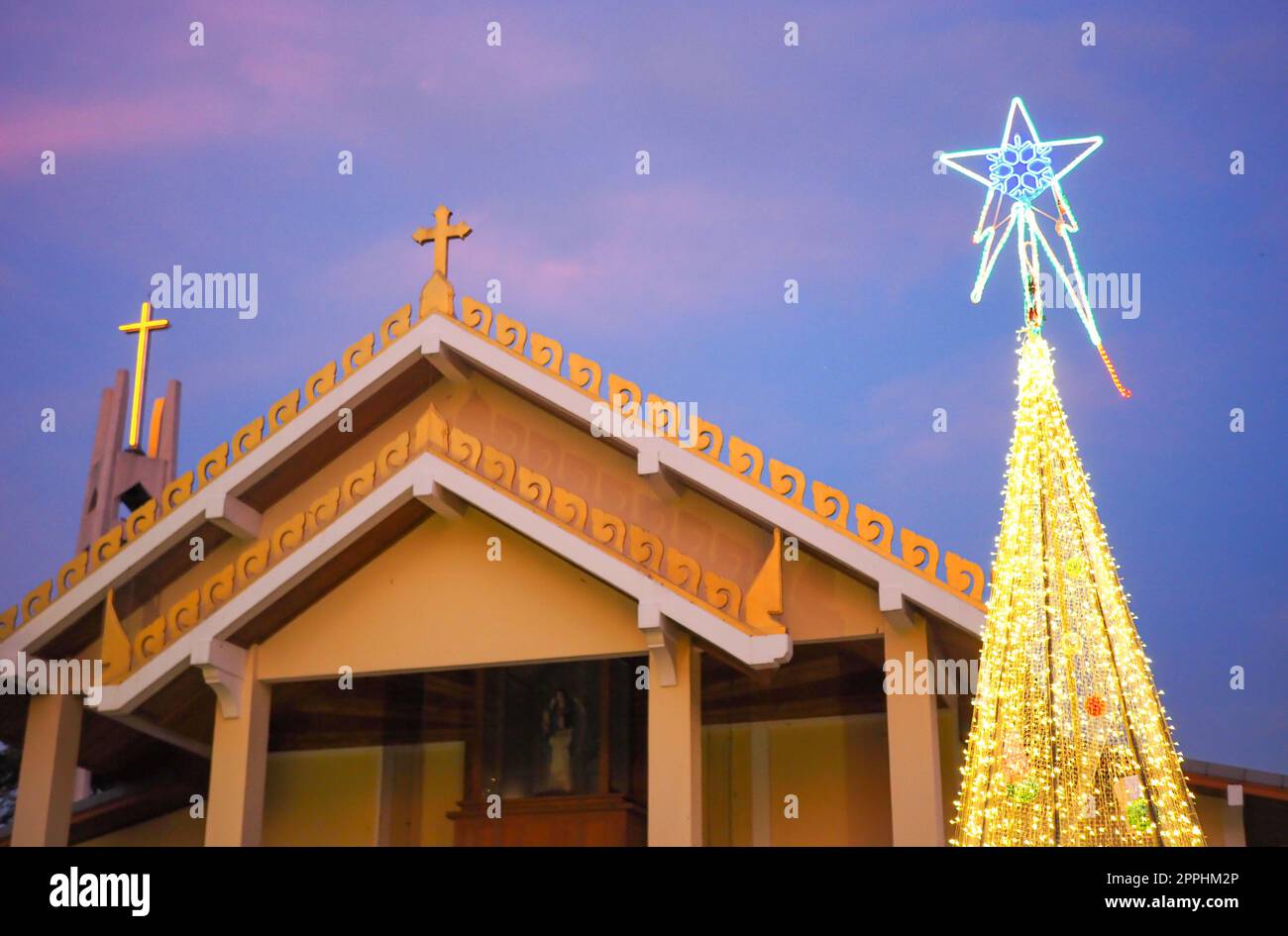 Catholic church with Christmas tree and lights at night Stock Photo