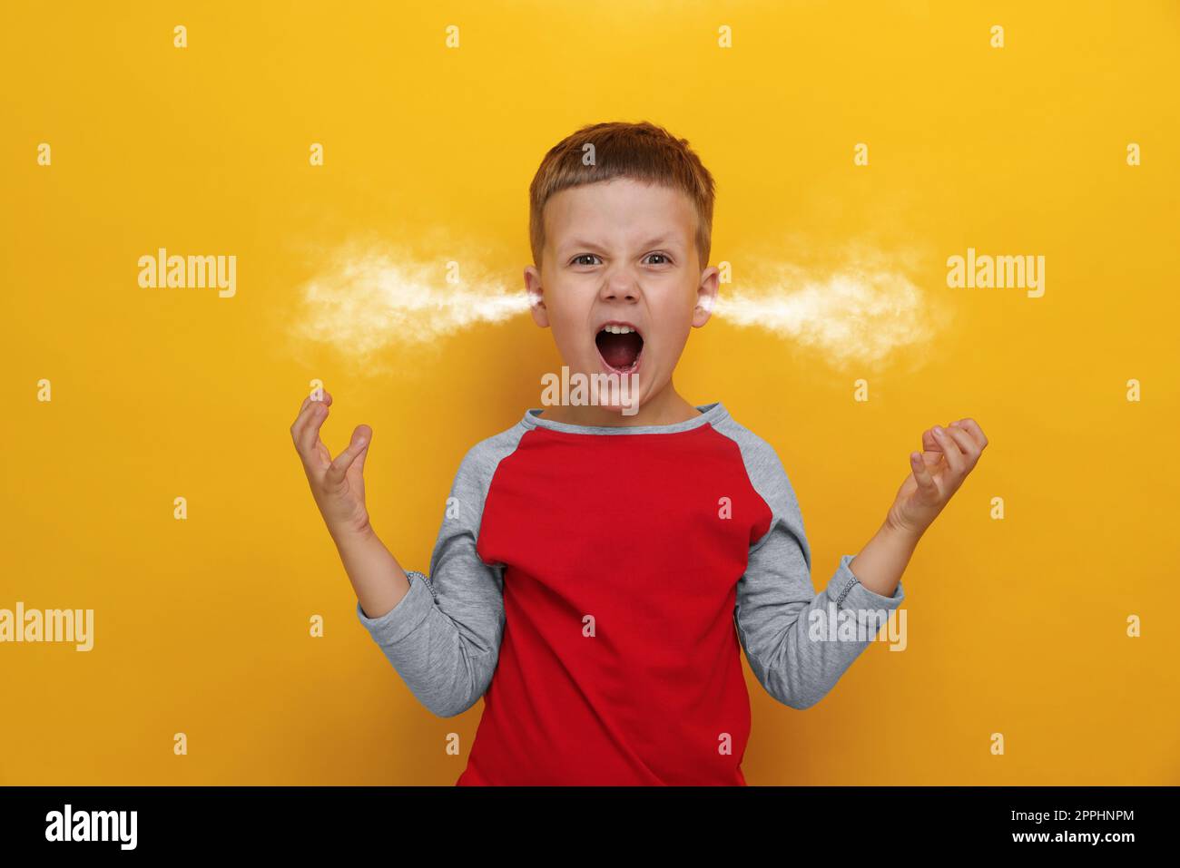 Aggressive little boy with steam coming out of his ears on orange background Stock Photo